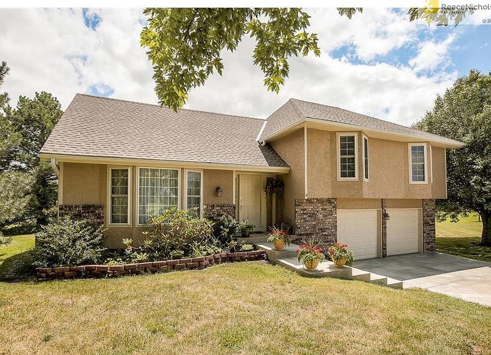 Stucco front with brick trim, newer steps and new driveway.