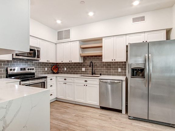 Fully-equipped kitchen with side by side refrigerator
