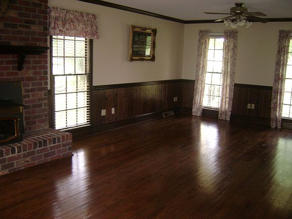The large great room has gleaming hardwood floors and a fireplace.