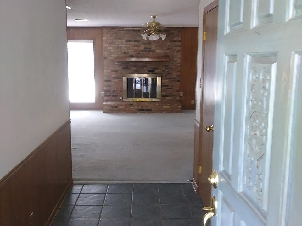 Tiled formal entry leading to spacious living room with gas log fireplace.