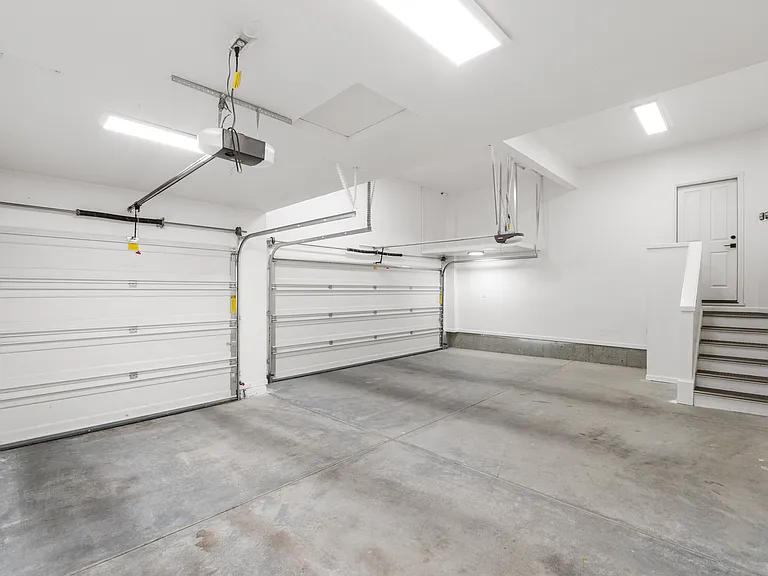 Spacious garage - one side features a 2-car garage door, other is a single garage door