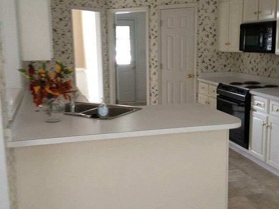 Kitchen with stove, microwave, dishwasher, refrigerator, wal