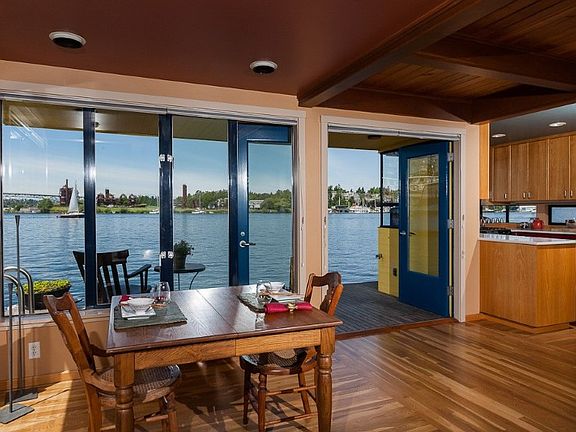 Dining room w/delicious water views thru walls of windows & glass doors that open onto covered deck