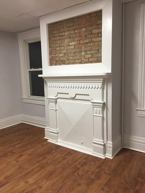 First floor bedroom with original fireplace feature and new floor