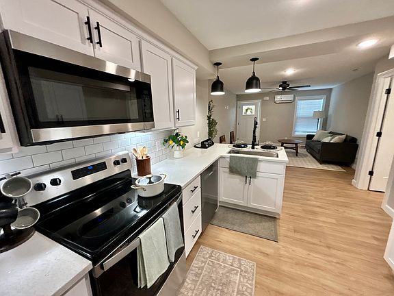 Kitchen features luxury vinyl plank, stainless steel appliances and quartz countertops