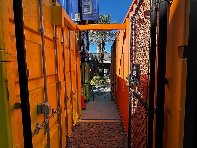 An alley defined by shipping containers leads to a secret garden in the private courtyard.