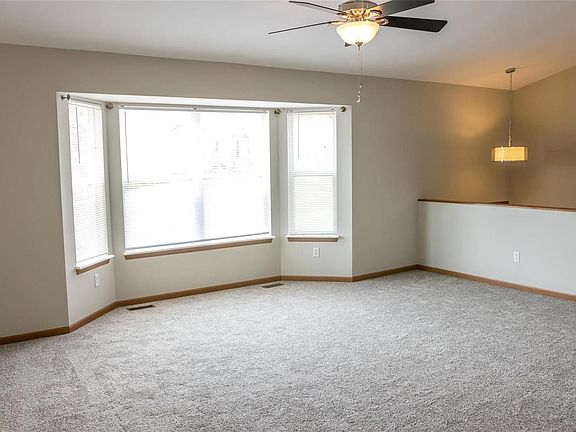 Spacious living room with vaulted ceiling and large bay window