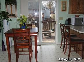 Kitchen leads to deck overlooking fenced in yard