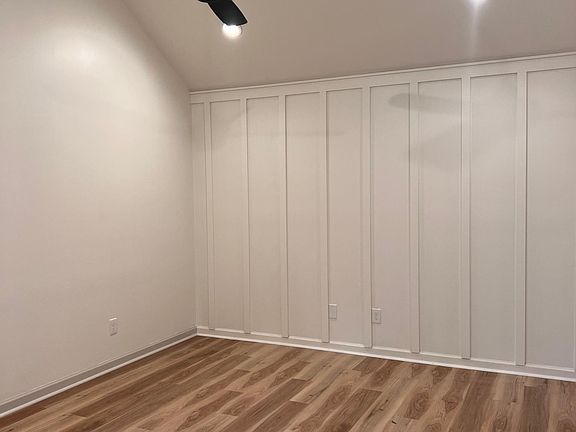 The master bedroom has high ceilings, master closet, and an ensuite bathroom that features tile floors and a vanity and shower.