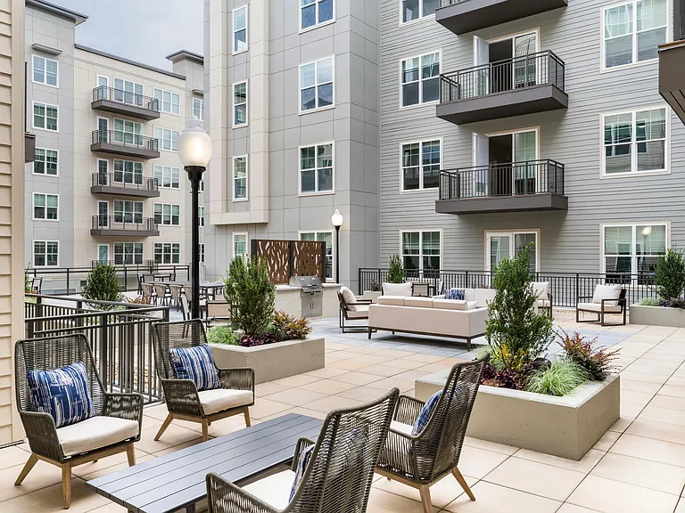 The courtyard at Modera Liberty Row offers stylish seating and greenery, creating a welcoming outdoor escape in the heart of Charlotte.