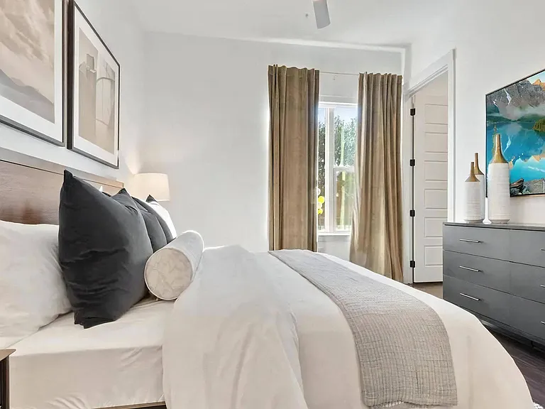 Bedroom with Framed Artwork, Dresser, and Wall-Mounted TV