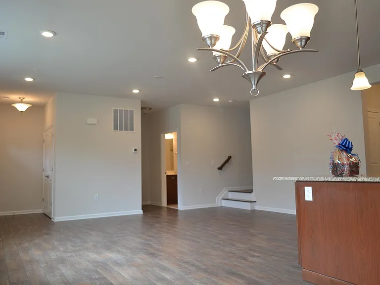 Downstairs with the view of the stairs up to the second floor, and the entry of the first floor full bath.