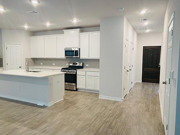 Stainless steel appliances with white cabinets.