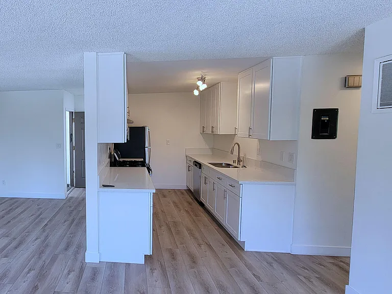 View of kitchen and front entry in 2-bedroom apartment at the Hardison Apartments in Pasadena, California.