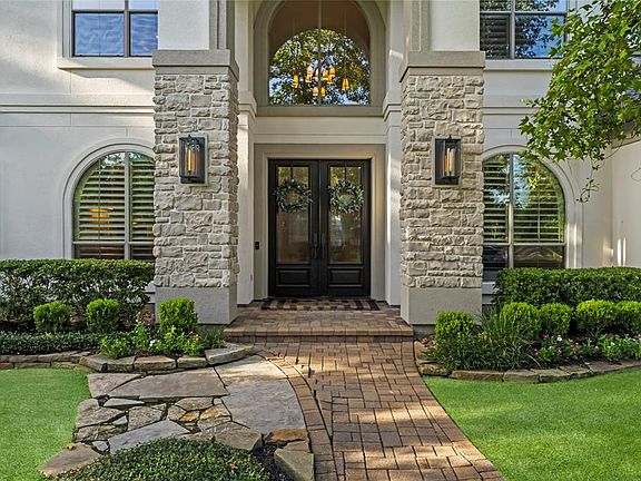 Covered porched with stone columns, new Restoration Hardware exterior lighting and double front doors make an impressive entry into the home.