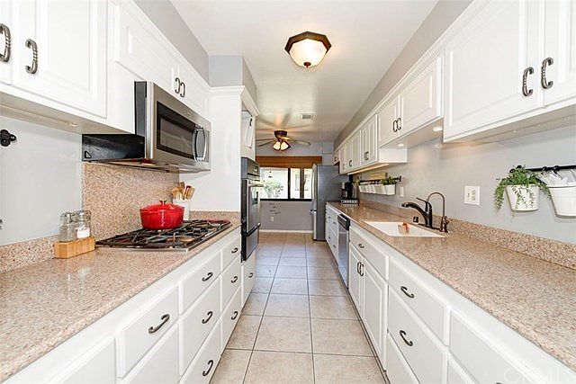 Beautiful kitchen with breakfast nook at the end. Window with view to outside landscape.
