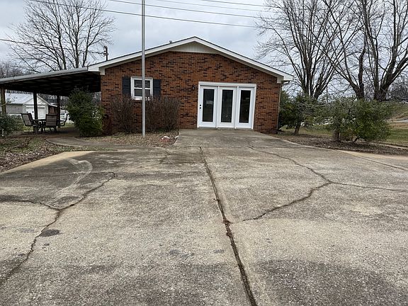 Parking area view of home with entrance to sunroom and back porch entrance.