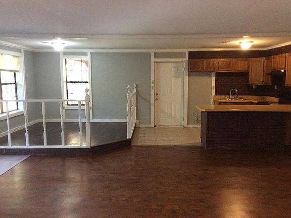 Kitchen and raised dining area are open to the living room. There are lota of windows.