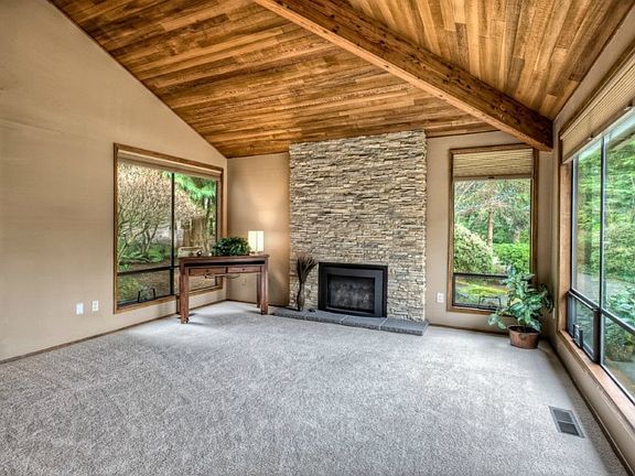 Anyone would undoubtedly enjoy this fabulous living room with the new gas insert surrounded by this beautiful new stone work. An impressive cedar ceiling draws in the lush greenery outside through all the ample windows.