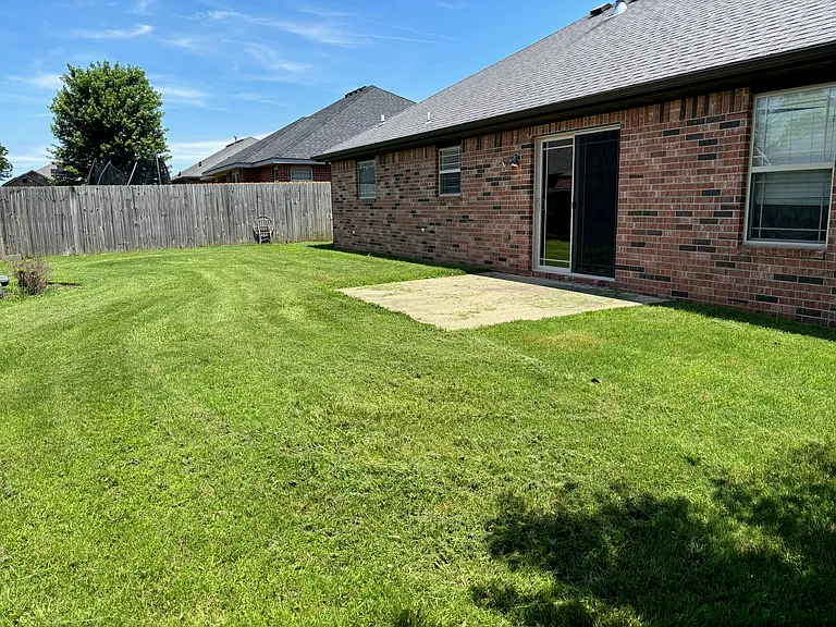 Fenced in backyard with patio
