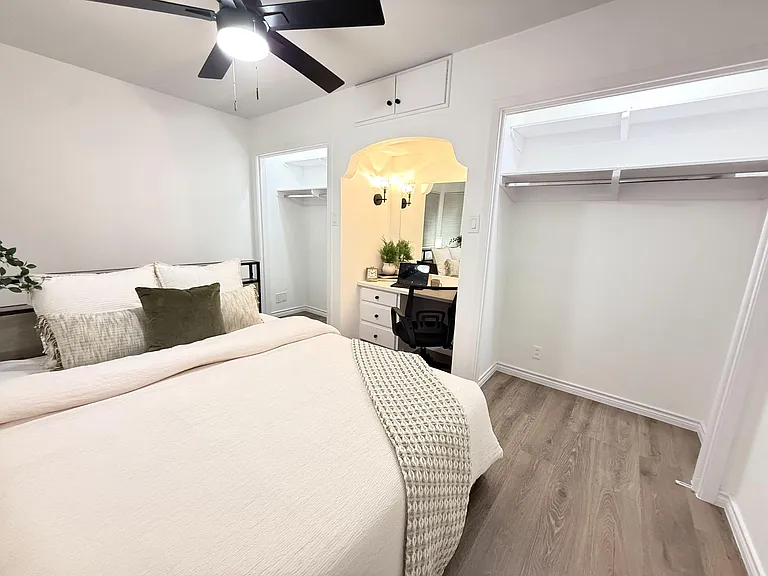 This rooms has lots of storage space and a light and bright nook behind the bed for a seating area or extra workspace.