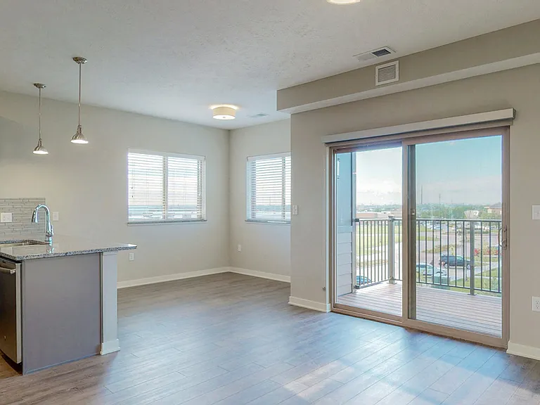 The 2 bedroom Marigold with den floor plan at WH Flats features natural light and a spacious dining and living area with electric fireplace.