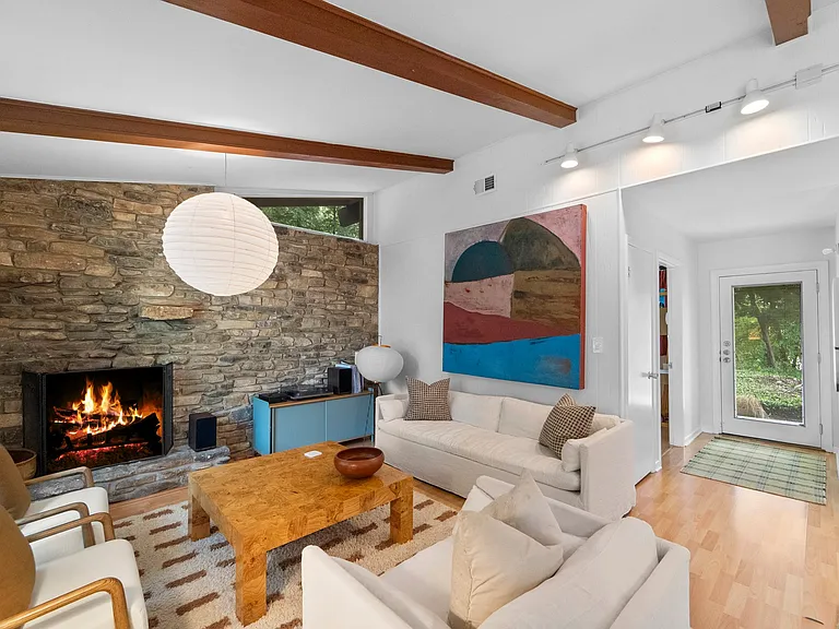 First living area. Working fireplace. Door at center to secondary bedroom or office. Looking to front entry.