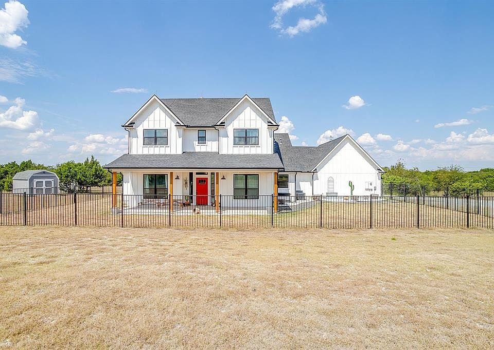 Modern farmhouse style home with board and batten siding, covered porch, and roof with shingles