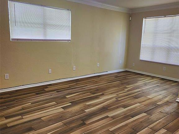 Living room featuring ceiling fan, crown molding, and dark laminate wood-style floors