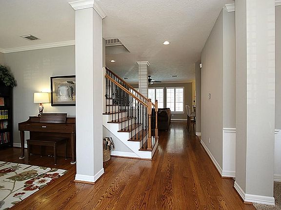 Entrance With Wide Plank Wood Floors. Metal Spindles Up The Staircase.