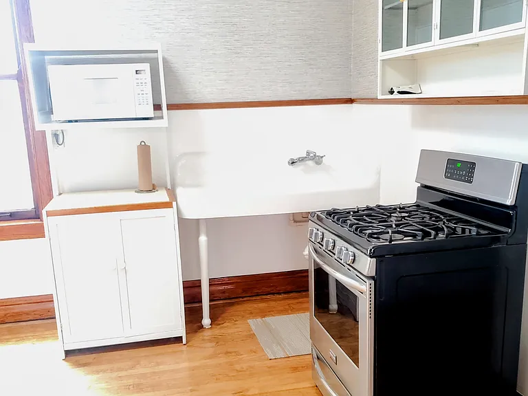 Kitchen: Newly refinished antique Farmhouse cast iron sink; wood hutch w. microwave, stainless steel stove. Metal kitchen cabinet w. smoked glass doors. SS refrigerator, second wall cabinet to left (not visible in pics).
