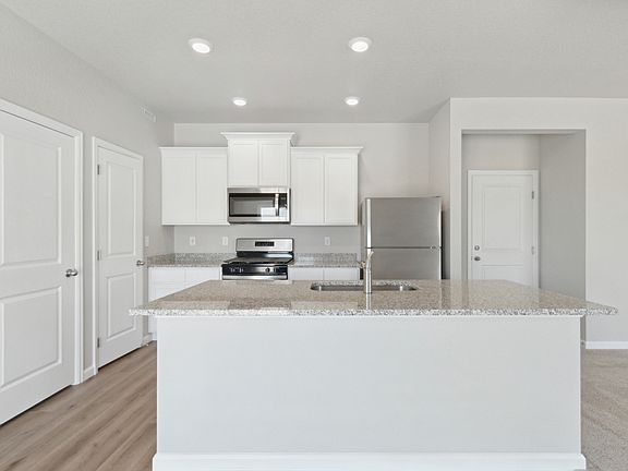 The kitchen of the Platte has beautiful white wood cabinets.