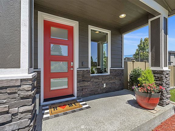 Beautiful covered front porch with unique tempered glass door. 