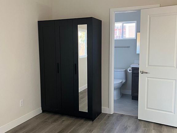 Bedroom has clothes armoire.