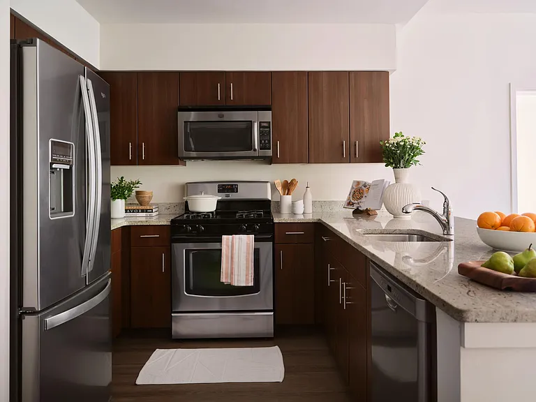 Gourmet kitchens with quartz or granite countertops, custom cabinetry, and Moen fixtures at The Metropolitan at 40 Park*.