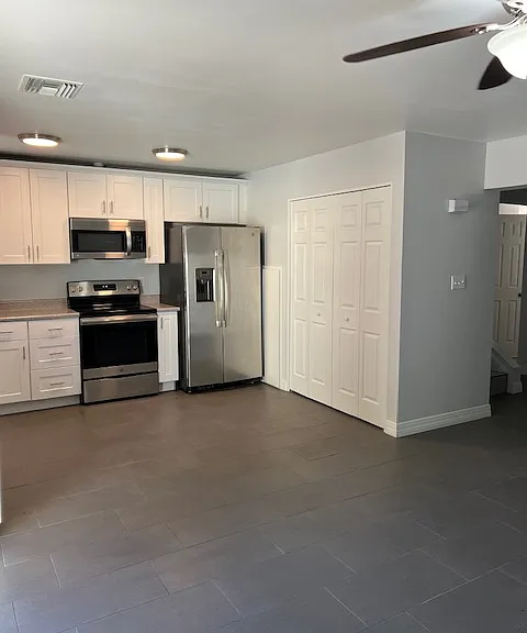 Kitchen, Kitchen Lighting, Cabinets, Appliances, Laundry Closet, Tile and Grout Flooring, Dining Room, Baseboard Molding, Ceiling Fan with Light.