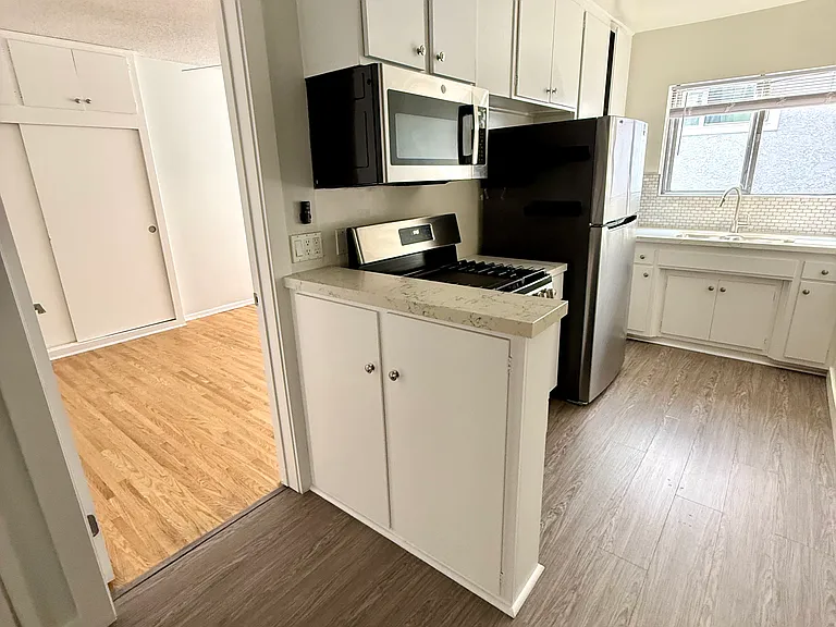 View of the kitchen, door into the bedroom.