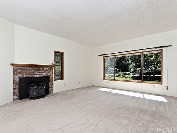 Very spacious living room with the fireplace insert and a unique stained-glass window.  There is a sliding glass door to the right that leads to a huge deck.