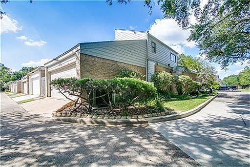 Back alley view with 2 car garage, side green space, park like setting with 2 community pools for your enjoyment.