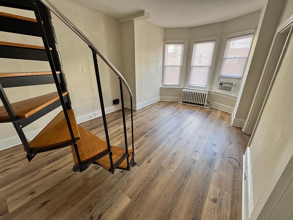 Living room/dining room area with bay window and new wood floors.