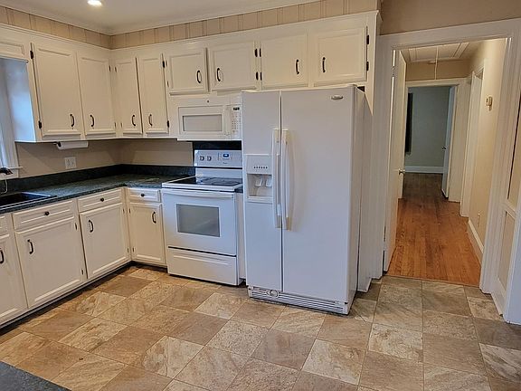 Another view of kitchen with refrigerator, built-in microwave and dishwasher.