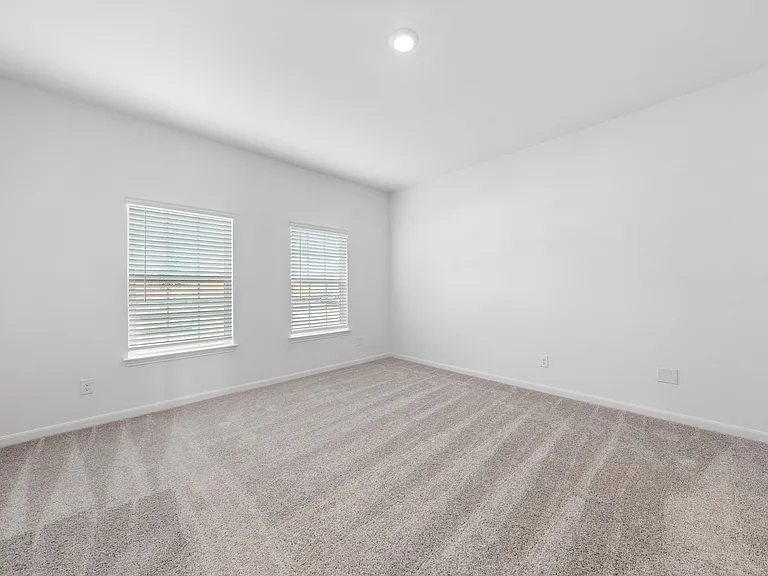 Downstairs master bedroom with two windows.