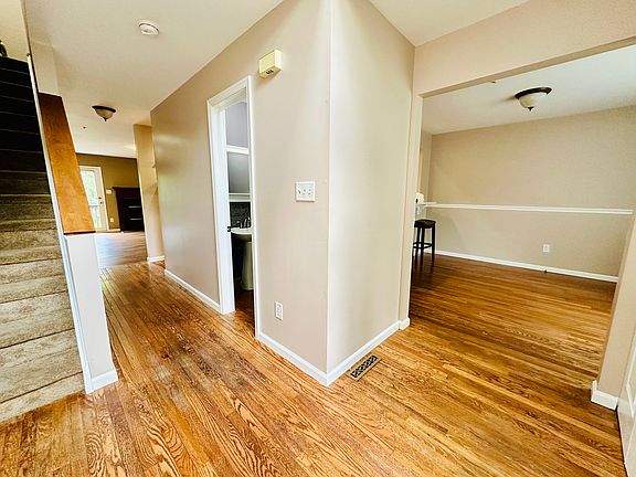 Entry way with powder room leading into dining room and hallway to living room.