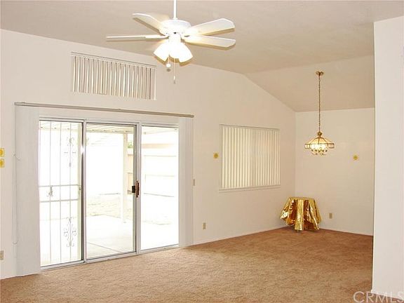 VIEW OF SPACIOUS LIVING ROOM WITH DRAMATIC VOLUME CEILINGS AND OPEN CONCEPT LIVING ROOM, DINING ROOM AND BACKYARD COVERED PATIO.