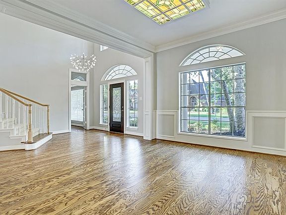 Impressive foyer and Formal Dining room with gleaming hardwood floors, and illuminated with tons of natural light beaming through arched windows
