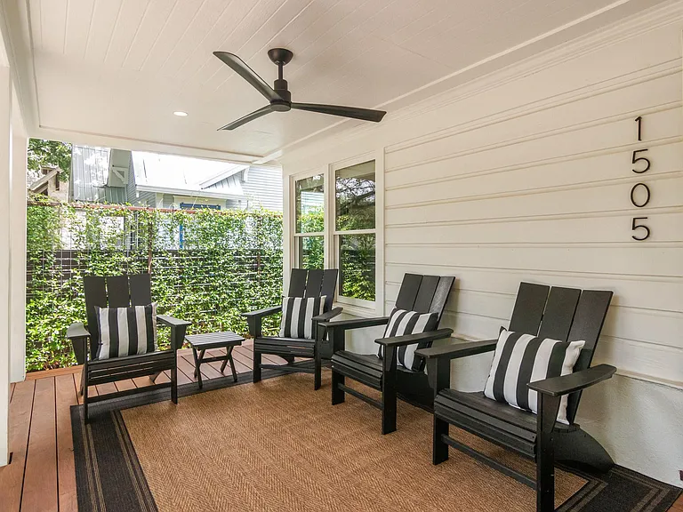 Front porch with ratan rug and privacy fence.