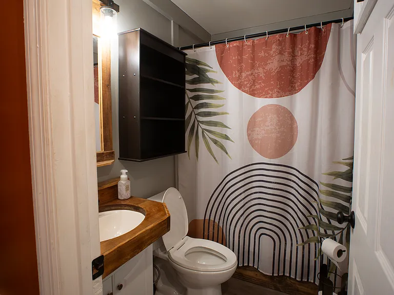 Guest bathroom: Shower/bath combo equipped with removable handheld shower head for easy cleaning.