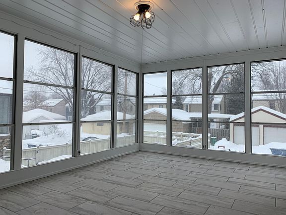 Three season porch with floor to ceiling windows and shiplap ceiling