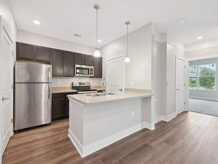 Dooley's Orchard unit showing a modern kitchen with a white island and wooden floors.