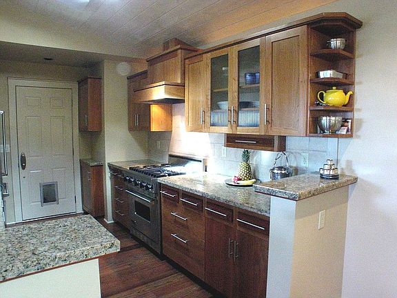 Custom Cabinetry Viking range/oven & refrigerator.  Granite slab counters.